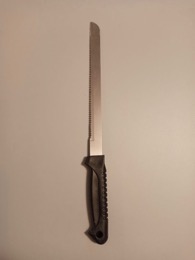 Cuchillo de sierra largo con empuñadura en color negro | 34 cm